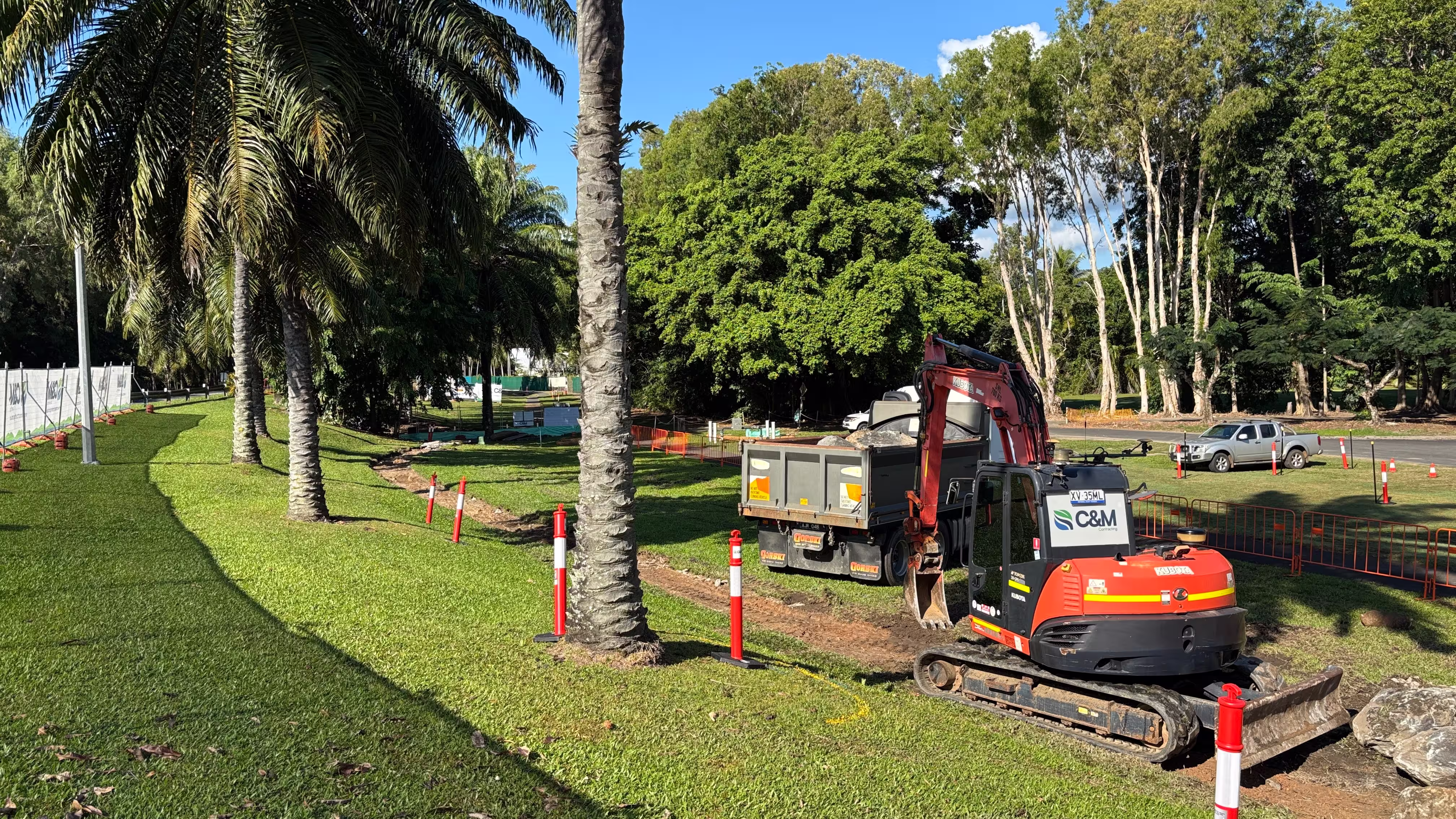 Heavy machinery on site at the Port Douglas footpath upgrade with tropical palms in the background